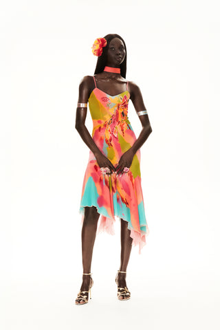 Cybersweeties Model wearing a colourful evening dress with floral patterns on a white background. The Tulipa cocktail dress. 2000s, vintage style with flower in her hair 