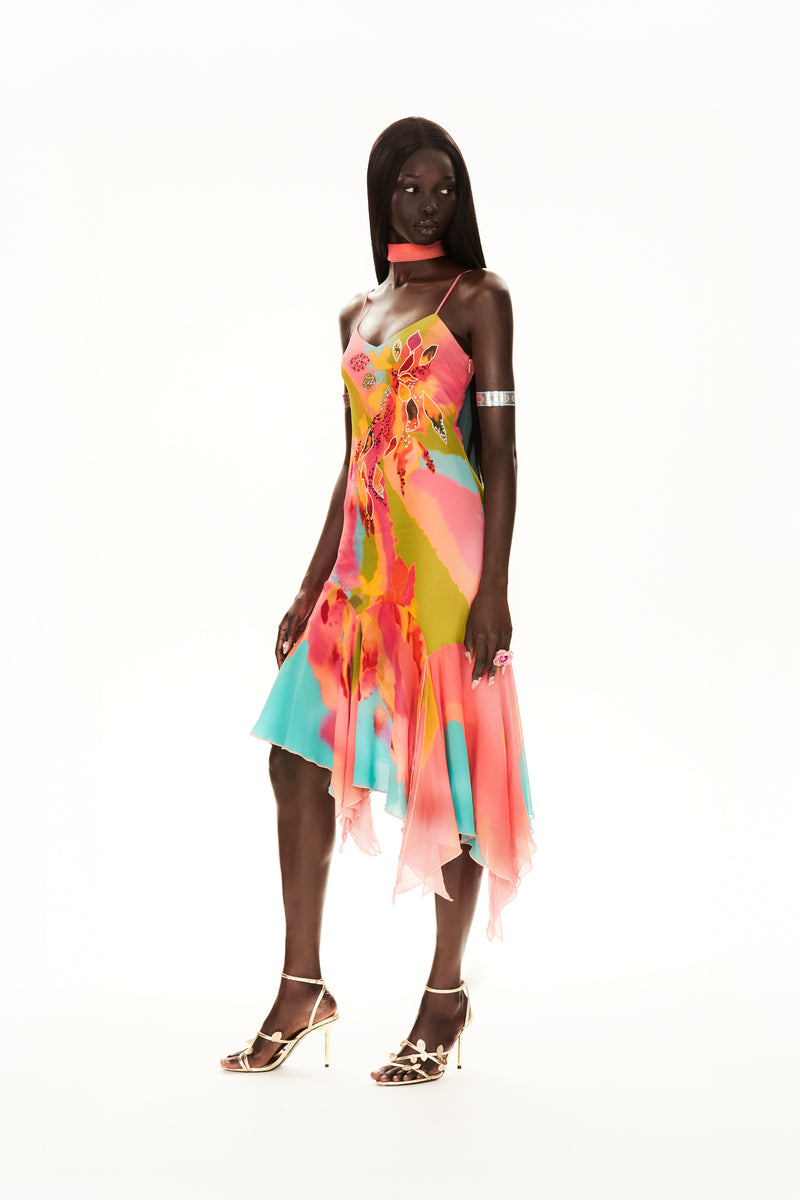 Cybersweeties Model wearing a colourful evening dress with floral patterns on a white background. The Tulipa cocktail dress. 2000s, vintage style 