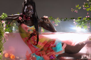 Cybersweeties model in a colourful dress lying on a water tank with floral decorations.  y2k & 2000s. The Tulipa cocktail gown - Limited edition hand painted

